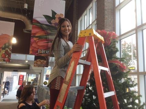 Chief Elf Brooke Simpson and Gina Buckner putting a tree up at Food City. Brooke is the brains amongst the paper work to keep things organized.