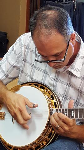 Stuart Wyrick is tuning and picking a banjo