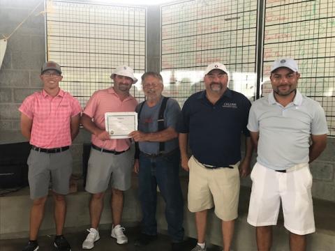 Men receiving award for golf tournament first place.