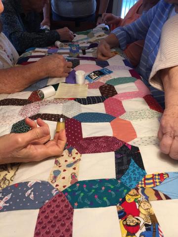 Sharps Chapel Quilters work on a quilt started by a woman who passed away due to cancer.