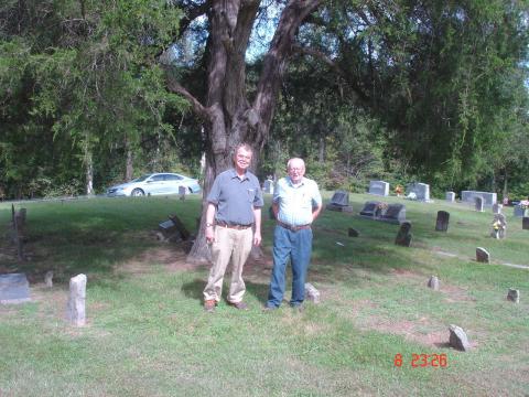 Jay Ricketts and John Cabage standing near the burial site of Alfred Gallatin Rickets in Cabbage Cemetery