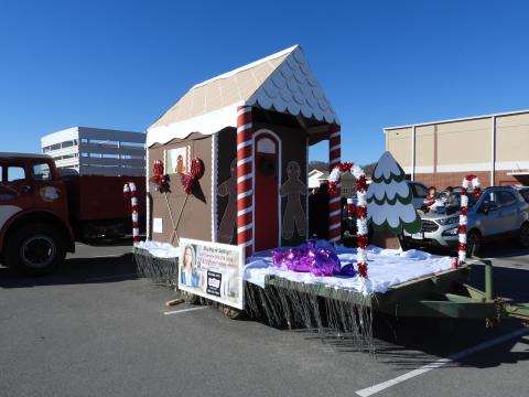 Float with house decorated for Christmas in a parade