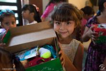Picture of little girl opening Operation Christmas Child Shoe Box.